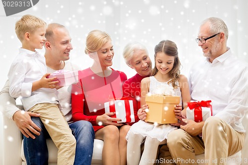 Image of smiling family with gifts at home