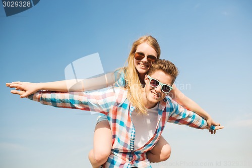 Image of smiling couple having fun outdoors