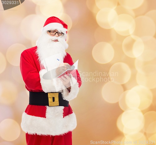 Image of man in costume of santa claus with notepad