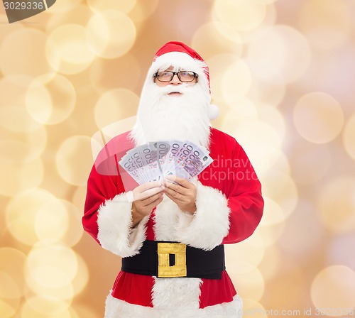 Image of man in costume of santa claus with euro money