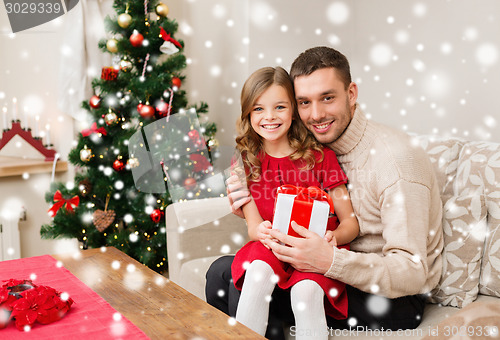 Image of smiling father and daughter holding gift box