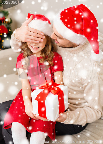 Image of smiling father and daughter holding gift box