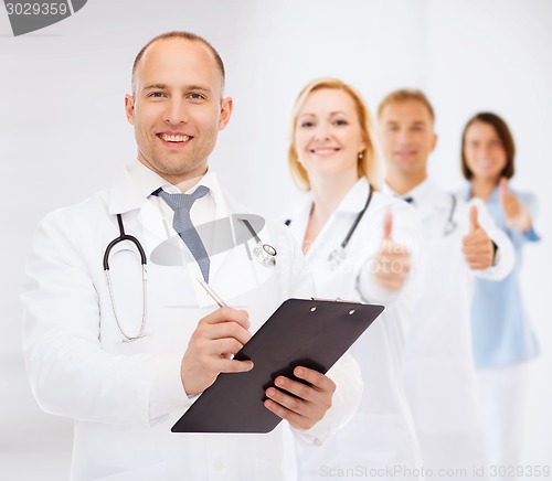 Image of smiling male doctor with clipboard and stethoscope