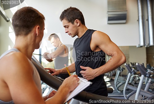 Image of men exercising on treadmill in gym