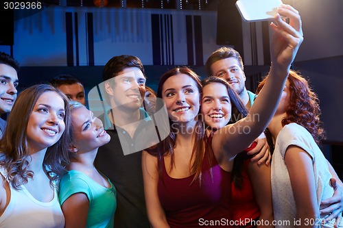 Image of friends with smartphone taking selfie in club