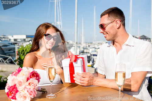 Image of smiling couple with gift box cafe