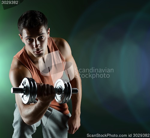 Image of young man with dumbbell flexing biceps