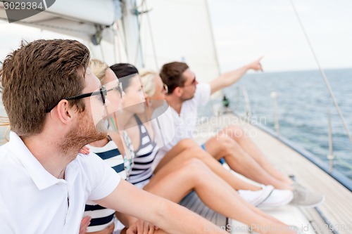 Image of smiling friends sitting on yacht deck