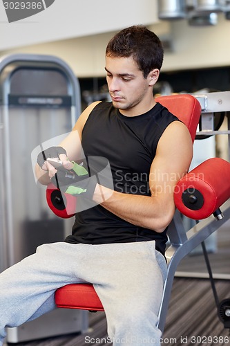 Image of young man with smartphone in gym