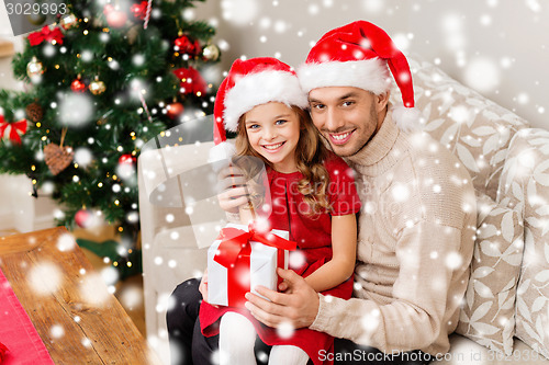 Image of smiling father and daughter holding gift box