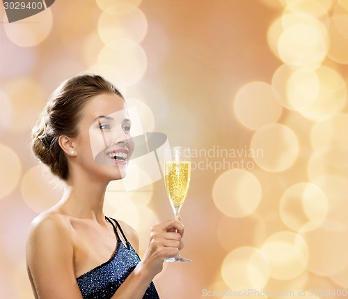 Image of smiling woman holding glass of sparkling wine