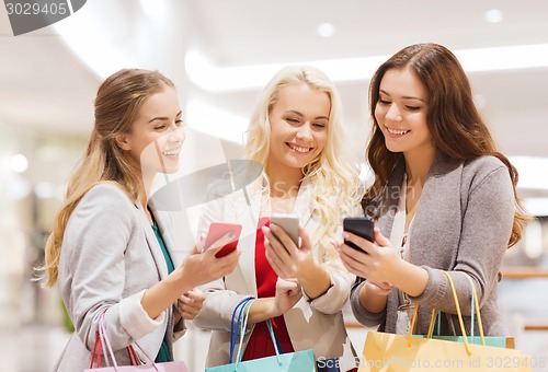 Image of happy women with smartphones and shopping bags