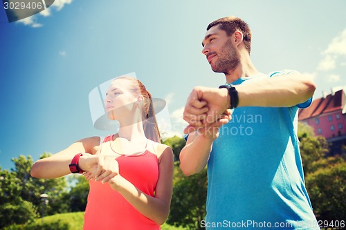 Image of smiling people with heart rate watches outdoors