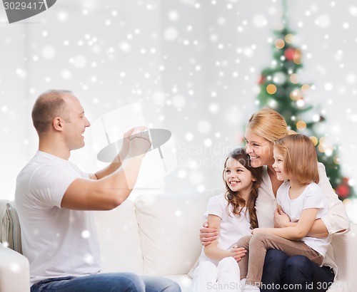 Image of happy family with camera at home