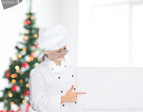 Image of smiling female chef with white blank board