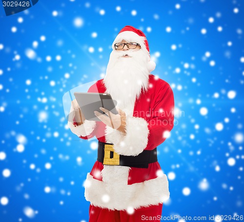 Image of man in costume of santa claus with tablet pc