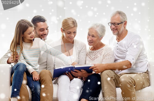 Image of happy family with book or photo album at home