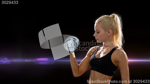 Image of young sporty woman with heavy steel dumbbell