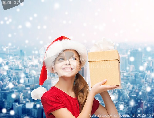 Image of smiling girl in santa helper hat with gift box