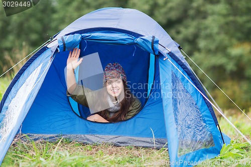 Image of smiling female tourist in tent