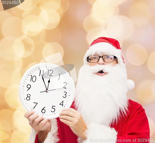 Image of man in costume of santa claus with clock