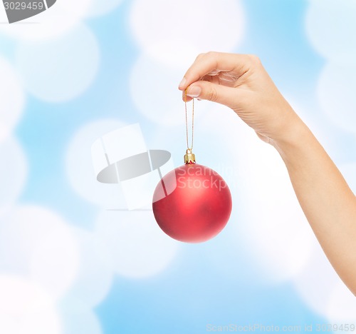 Image of close up of woman in sweater with christmas ball