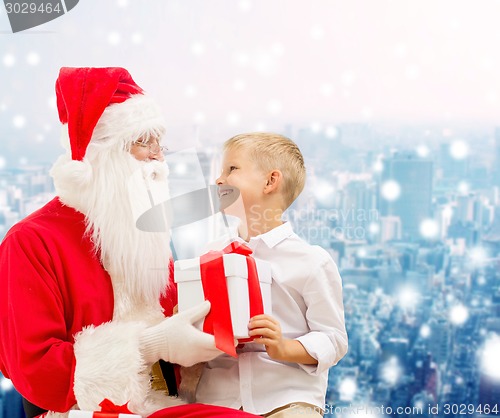 Image of smiling little boy with santa claus and gifts