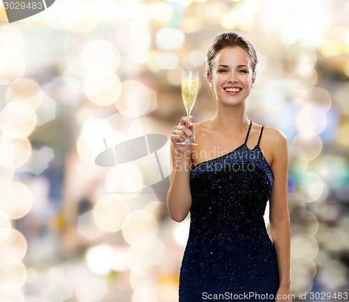 Image of smiling woman holding glass of sparkling wine