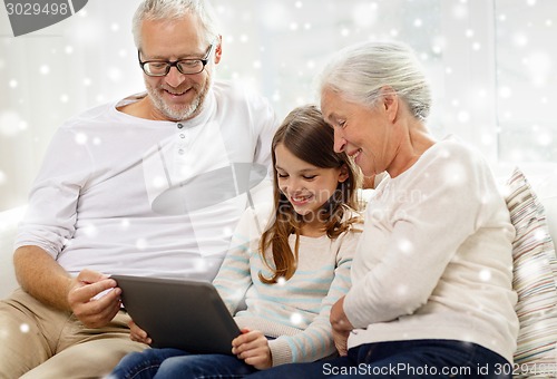 Image of smiling family with tablet pc at home