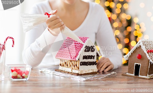 Image of close up of woman making gingerbread houses