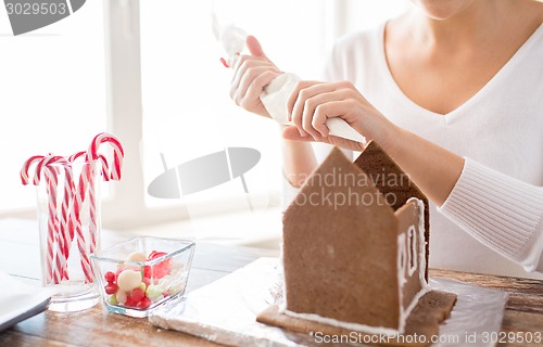 Image of close up of woman making gingerbread houses