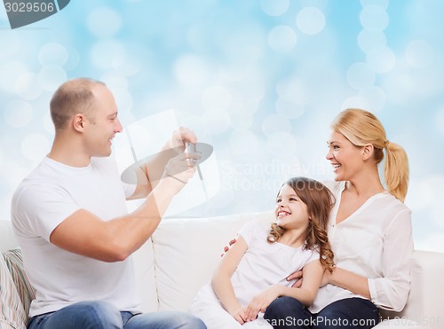 Image of happy family with camera at home