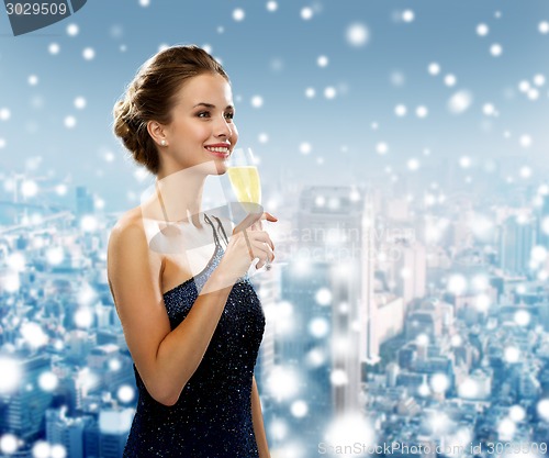 Image of smiling woman holding glass of sparkling wine