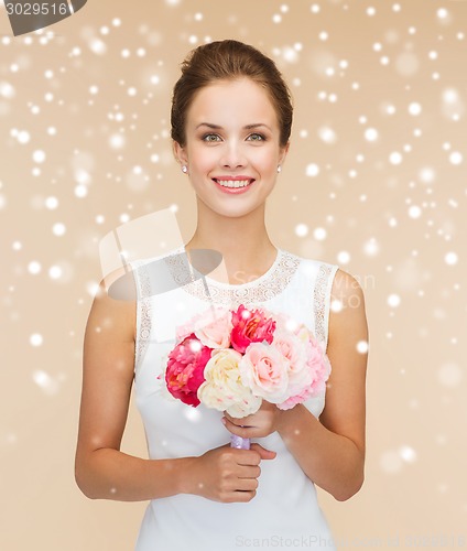 Image of smiling woman in white dress with flowers