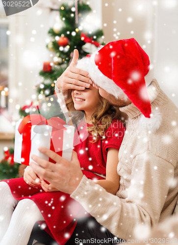 Image of smiling father and daughter holding gift box