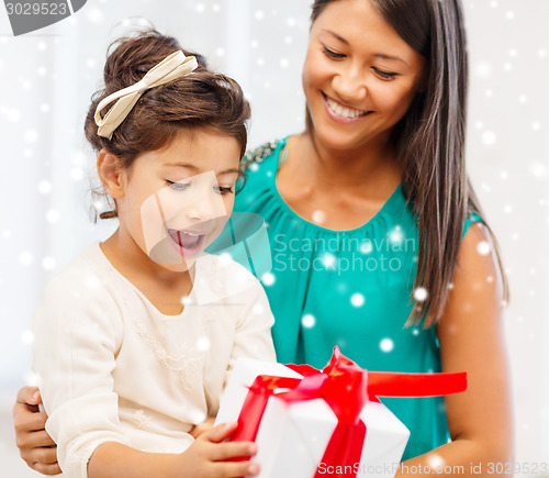 Image of happy mother and child girl with gift box