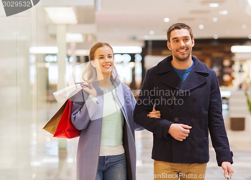 Image of happy young couple with shopping bags in mall