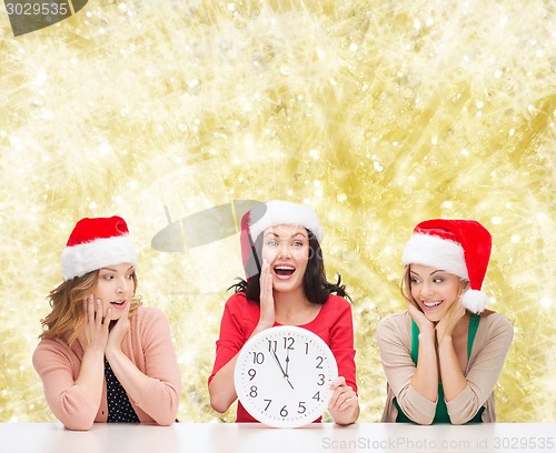 Image of smiling women in santa helper hat with clock