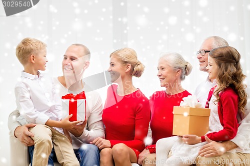 Image of smiling family with gifts at home