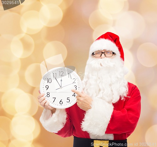 Image of man in costume of santa claus with clock