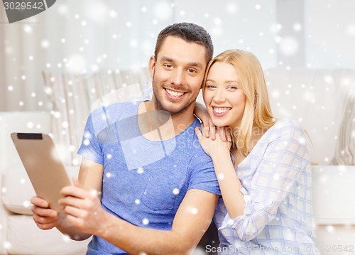 Image of smiling happy couple with tablet pc at home