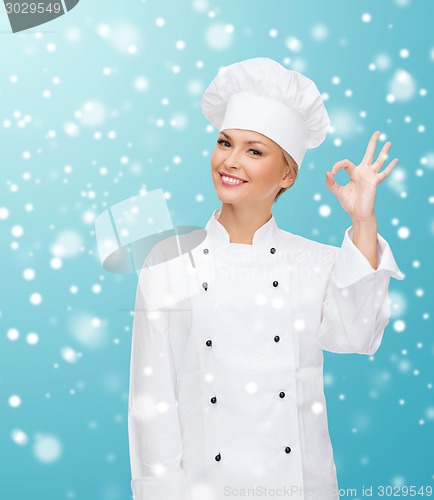 Image of smiling female chef showing ok hand sign