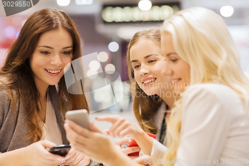 Image of happy women with smartphones and tablet pc in mall