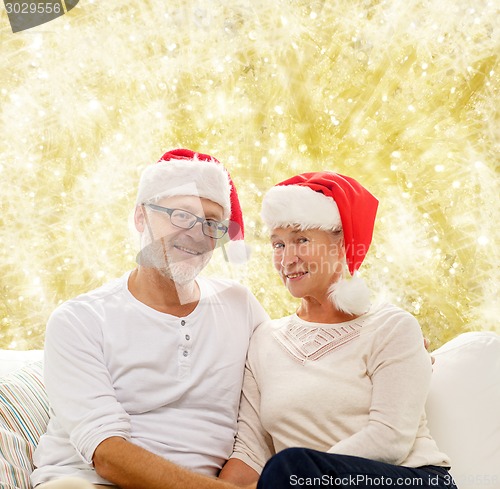 Image of happy senior couple in santa helper hats