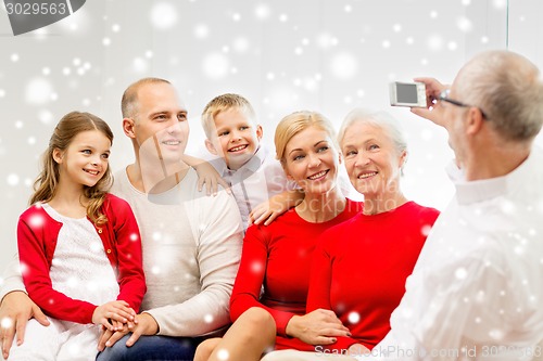 Image of smiling family with camera at home