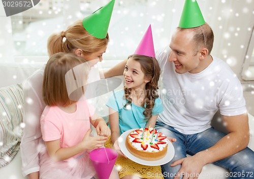 Image of happy family with two kids in party hats at home