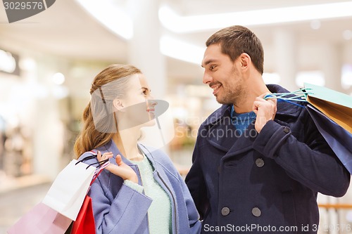 Image of happy young couple with shopping bags in mall