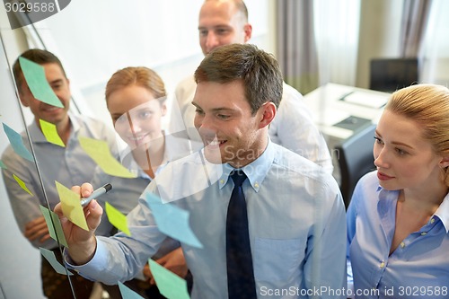 Image of smiling business people with marker and stickers