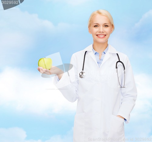 Image of smiling female doctor with green apple