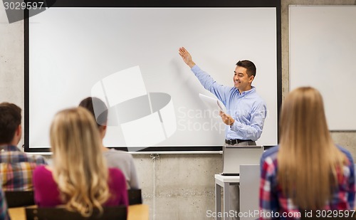 Image of group of students and smiling teacher with notepad